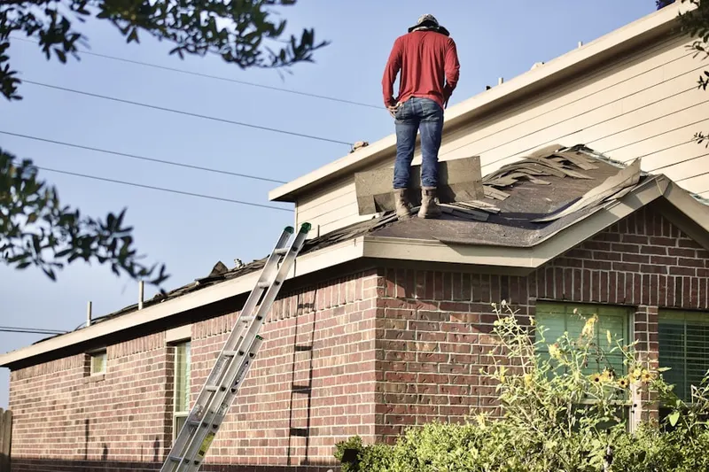 Professional roofer working on a residential roof in Woodedge Village